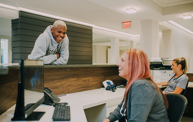 admission desk at Evolve with an admin and a patient chatting.